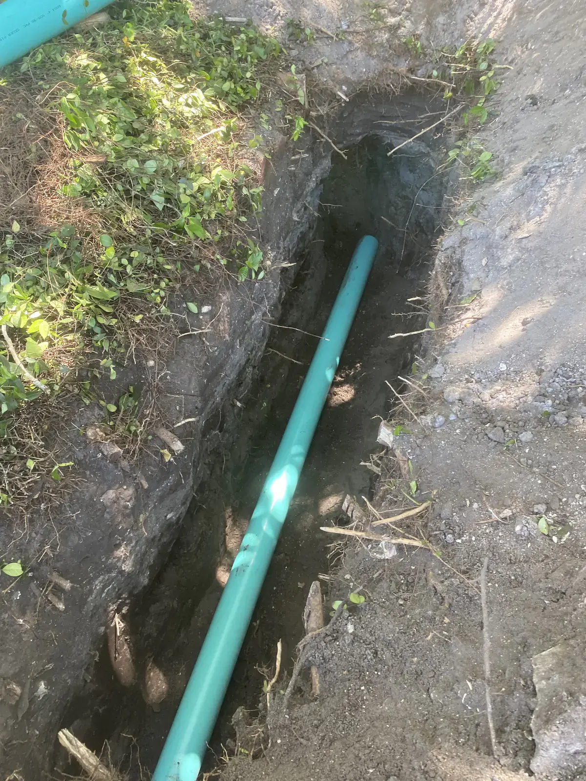 New green PVC sewer line installed at the correct slope in an open trench in Neptune Beach, FL