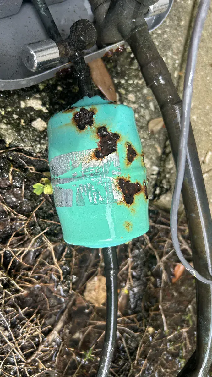 Rusty biflow filter drier showing corrosion damage